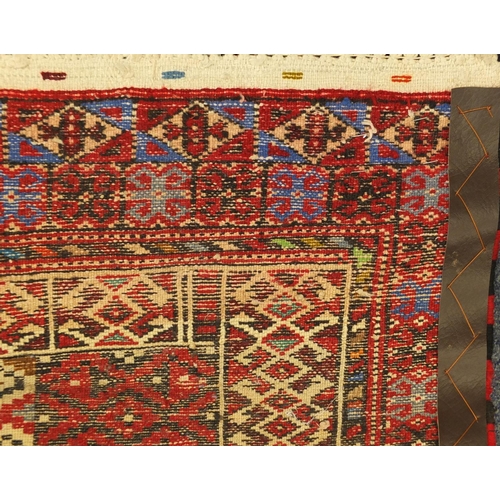 2052 - Rectangular Persian Baluchi rug, having an all over geometric design onto a red ground, 97cm x 81cm