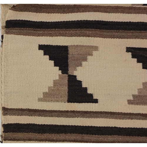 2043 - Rectangular Native American Navajo rug having an all over geometric design, 136cm x 70cm