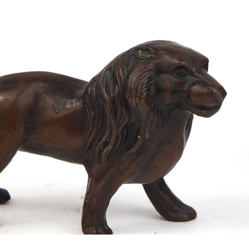 2380 - Black forest carved bear together with a bronze lion, the largest 14cm in length