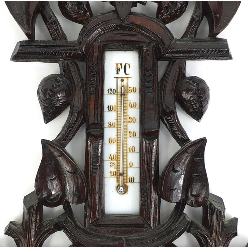 2255 - Black forest wall barometer thermometer carved with foliage, 47cm high