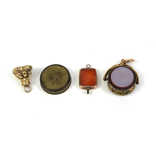 2622 - Three gilt metal hard stone fobs including a spinning locket together with a compass