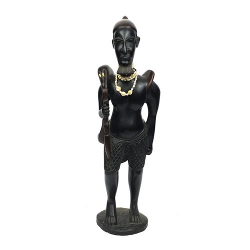 2256 - Floor standing model of an African Hunter carrying his prey with a cowrie shell necklace, 84cm high