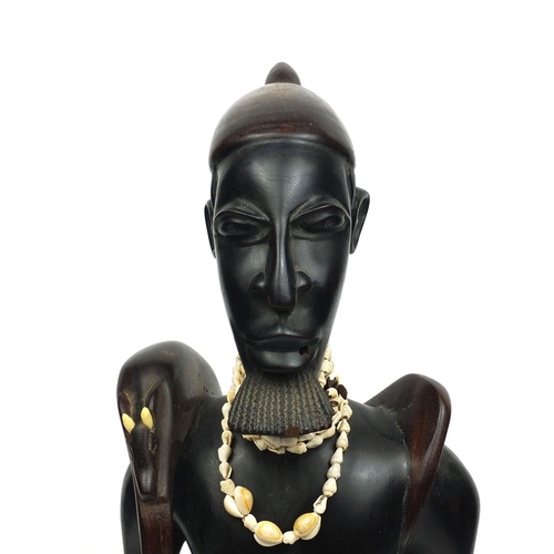 2256 - Floor standing model of an African Hunter carrying his prey with a cowrie shell necklace, 84cm high