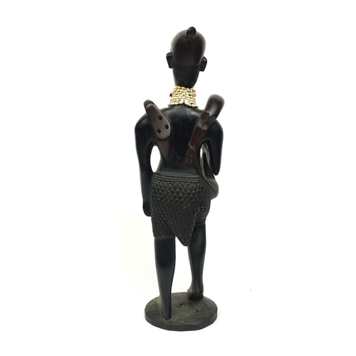 2256 - Floor standing model of an African Hunter carrying his prey with a cowrie shell necklace, 84cm high