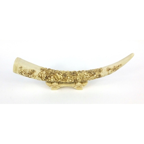 142 - Decorative Oriental resin tusk on stand, 44cm long