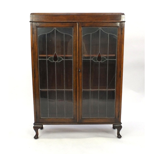 4 - Oak bookcase with leaded glazed doors, fitted with two shelves, 125cm high x 90cm wide x 28cm deep