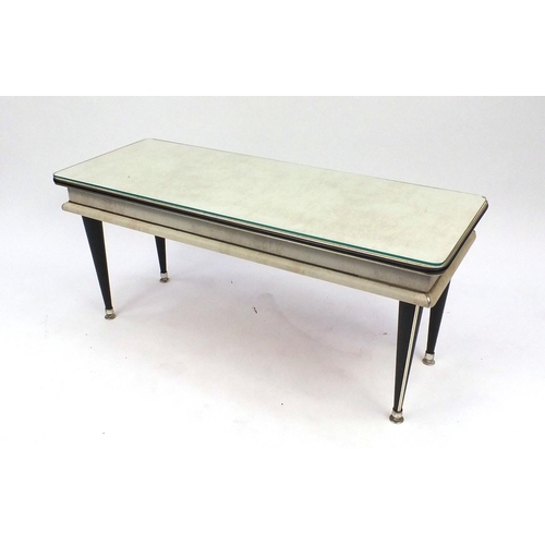 55 - Retro cream leatherette coffee table raised on tapering legs, 48cm high x 107cm wide x 41cm deep