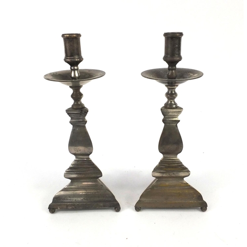 140 - Pair of triangular silver plated candle sticks, 34cm high