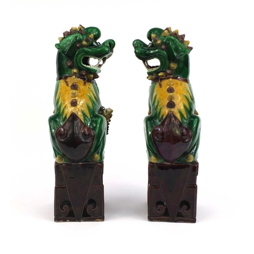 486 - Large pair of Chinese green and yellow glazed Foo Dogs, raised on square bases, each 41cm high