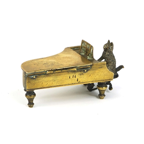 106 - 19th century cold painted bronze match striker, in the form of a cat playing a grand piano, the hing... 