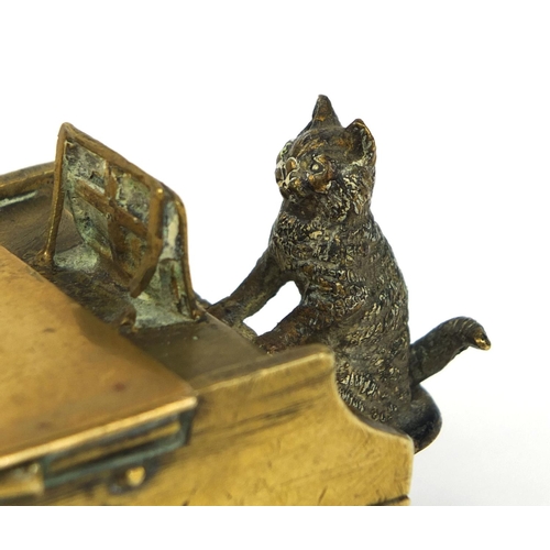 106 - 19th century cold painted bronze match striker, in the form of a cat playing a grand piano, the hing... 