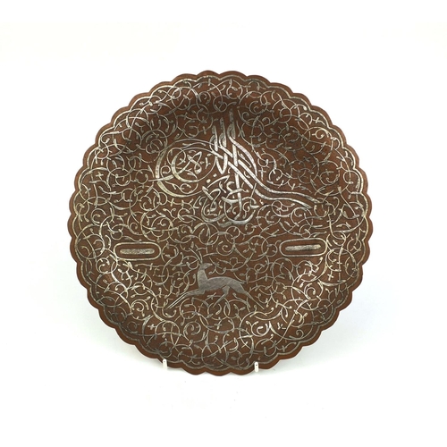 626 - Islamic copper and silver inlaid Cairoware dish, decorated with a leaping deer amongst script and fo... 