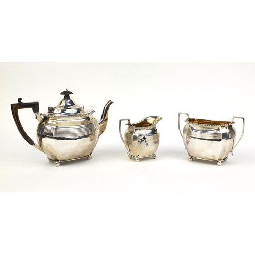 812 - Victorian silver three piece tea service with ball feet, the sugar bowl and milk jug with gilt inter... 