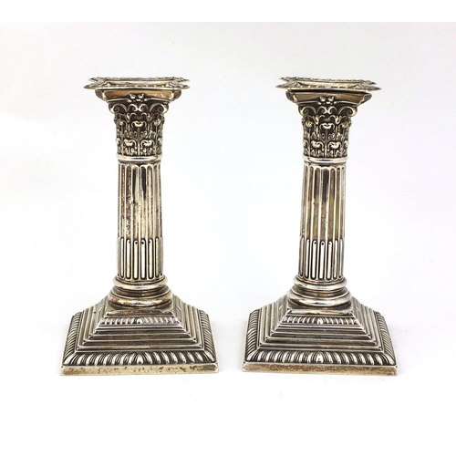 819 - Pair of silver Corinthian column candle sticks with square stepped bases, HA Sheffield 1909, 16cm hi... 