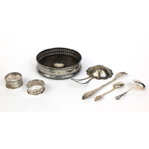 871 - Silver items comprising circular wine coaster, two sifting spoons, pair of napkin rings, teaspoon an... 