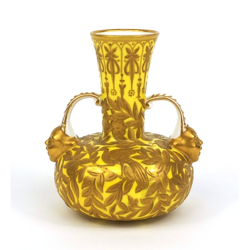 689 - Royal Crown Derby twin handled vase with mythical faces, hand gilded with foliage onto a yellow grou... 