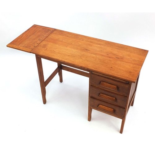 2034 - A M Coleman & Co light oak students desk with drop leaf and brushing slide fitted with three drawers... 
