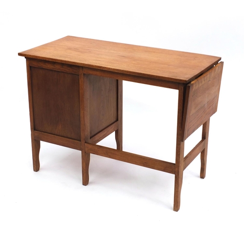 2034 - A M Coleman & Co light oak students desk with drop leaf and brushing slide fitted with three drawers... 