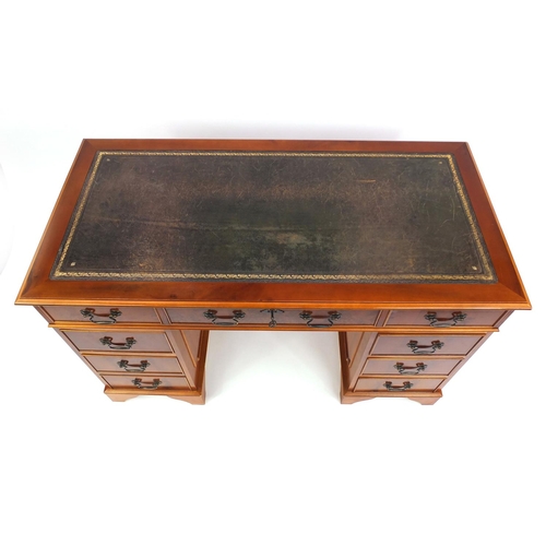2002 - Yew wood twin pedestal desk with tooled leather insert fitted with an arrangement of eight drawers, ... 