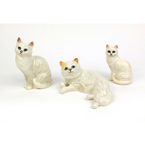 2080 - Three Beswick cats including an example laying down, each with factory marks and numbers to the base... 