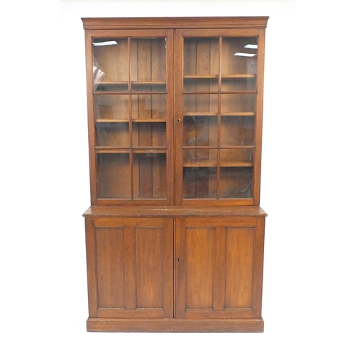 56 - Walnut bookcase fitted a pair of  glazed doors each enclosing three adjustable shelves, on a cupboar... 