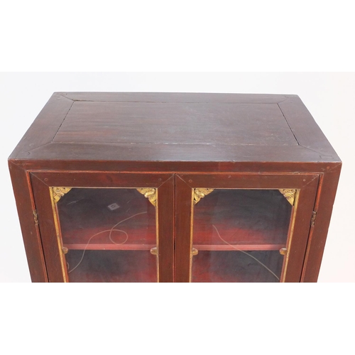 102 - Oriental display cabinet with glazed doors enclosing three shelves above an arrangement of drawers a... 