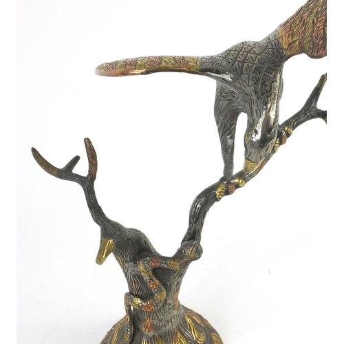 132 - Metal study of an eagle and a snake on a branch, 36cm high