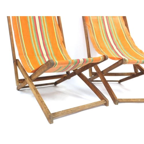 112 - Two vintage folding wooden deckchairs