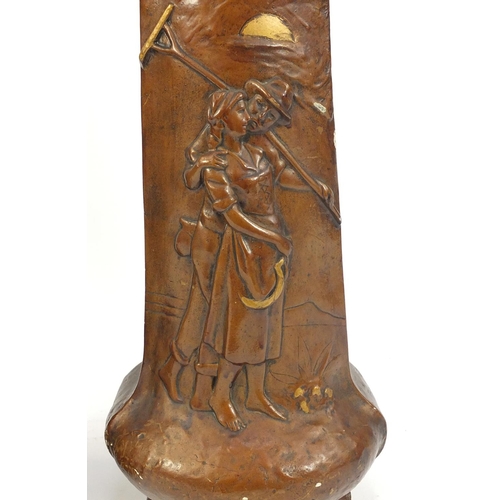 148 - Pair of Art pottery vases decorated in relief with farming couples, 40.5cm high