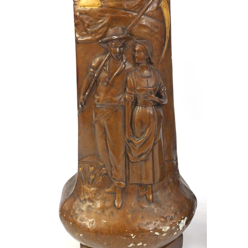 148 - Pair of Art pottery vases decorated in relief with farming couples, 40.5cm high