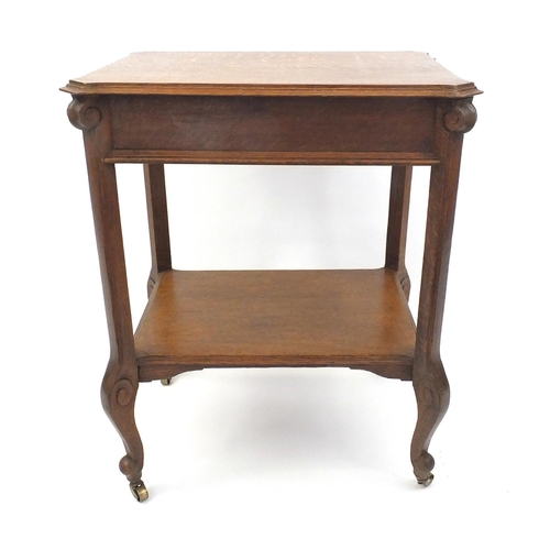 105 - Carved oak occasional table with under tier raised on cabriole legs and castors, 75cm high x 60cm wi... 