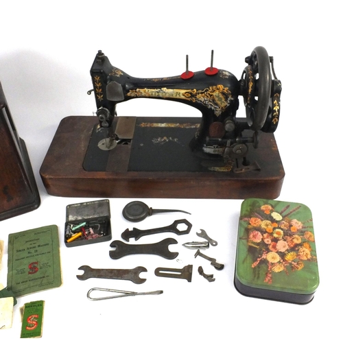 224 - Singer sewing machine, serial no. 14677853 and a tin of accessories