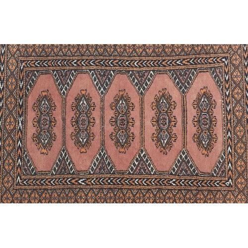 34 - Pink ground geometric patterned rug, 125cm x 80cm