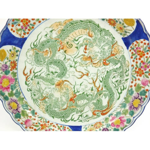 134 - Oriental porcelain charger transfer printed with dragon and hand painted floral boarder, 39cm in dia... 