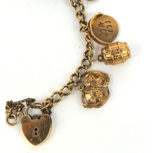 2439 - 9ct gold charm bracelet with a selection of charms including theatre masks, I love you spinner, four... 