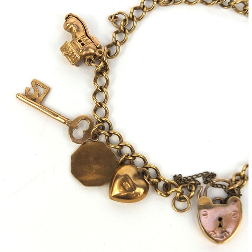 2439 - 9ct gold charm bracelet with a selection of charms including theatre masks, I love you spinner, four... 