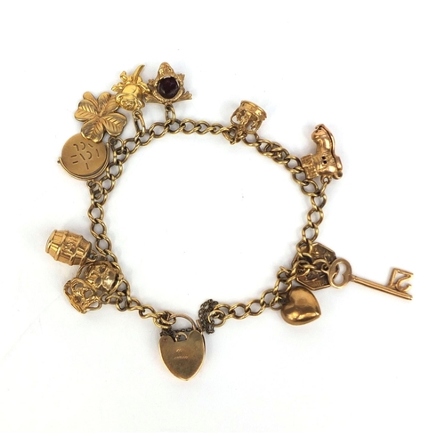 2439 - 9ct gold charm bracelet with a selection of charms including theatre masks, I love you spinner, four... 