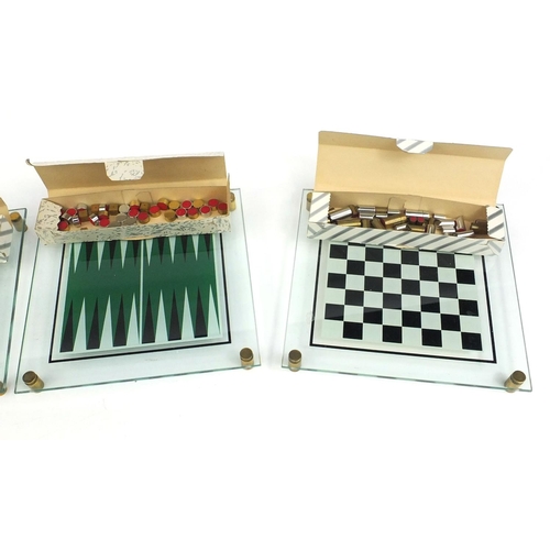 396 - Four boxed glass, brass and stainless steel backgammon and chess sets, designed and manufactured by ... 