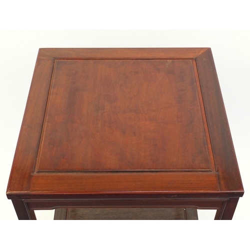 57 - Oriental hardwood occasional table with under tier and castors, 70cm high x 56cm square