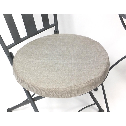 62 - Circular folding metal garden table and two chairs with cushion seats, 75cm high x 70cm in diameter