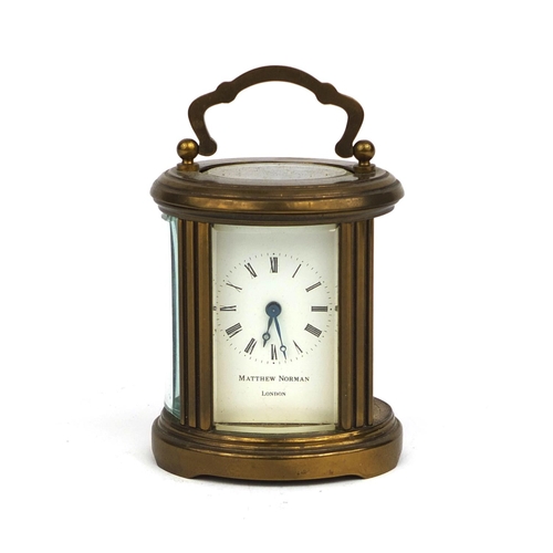 1102 - Matthew Norman of London oval brass cased carriage clock with bevelled glass and Roman numerals, 8cm... 