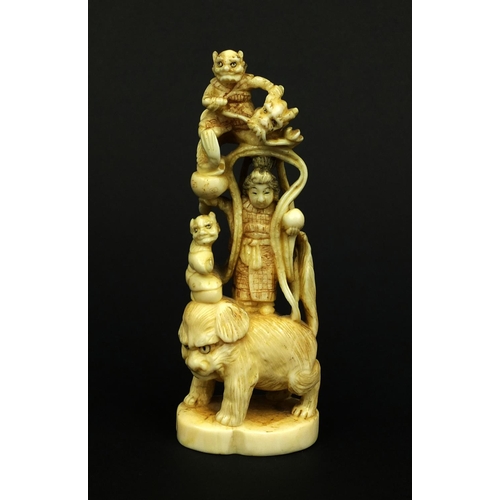 529 - Japanese carved ivory okimono of a Geisha girl standing on a lion, red insect character marks to the... 