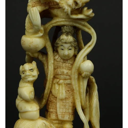 529 - Japanese carved ivory okimono of a Geisha girl standing on a lion, red insect character marks to the... 