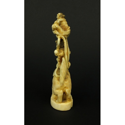 529 - Japanese carved ivory okimono of a Geisha girl standing on a lion, red insect character marks to the... 