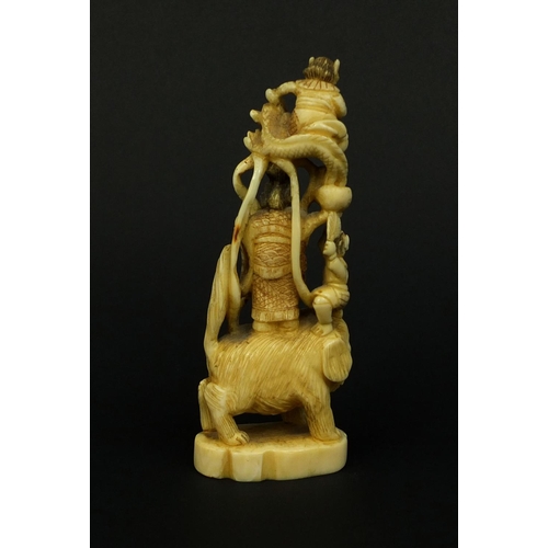 529 - Japanese carved ivory okimono of a Geisha girl standing on a lion, red insect character marks to the... 