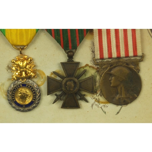 355 - Two framed displays of World War I French medals awarded to Caporal Coste Louis, each 39cm x 29cm ex... 