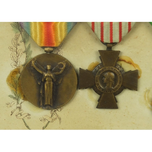 355 - Two framed displays of World War I French medals awarded to Caporal Coste Louis, each 39cm x 29cm ex... 