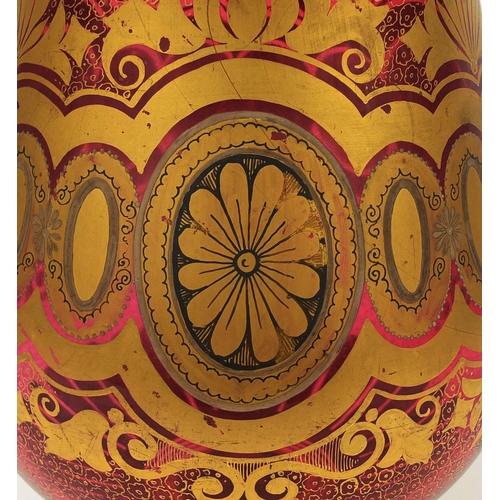 724 - Continental ruby glass vase and cover gilded with stylised floral motifs, 41cm high