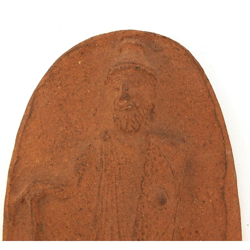 761 - Royal Doulton terracotta plaque decorated in relief with a man in armour, impressed marks to the rev... 