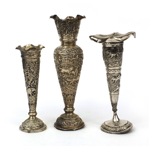 597 - Three Indian unmarked silver vases, each embossed with animals amongst trees and with frilled rims, ... 